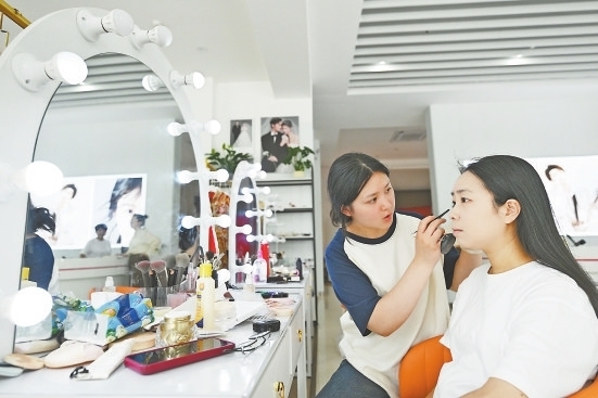领证跟拍摄影馆内，工作人员在为新人化妆。