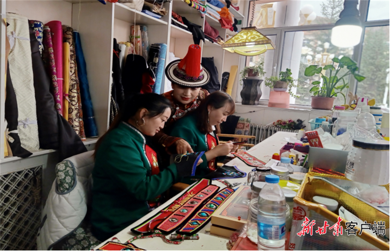 杨海燕指导徒弟刺绣（杨海燕右一，身穿裕固族服饰。）