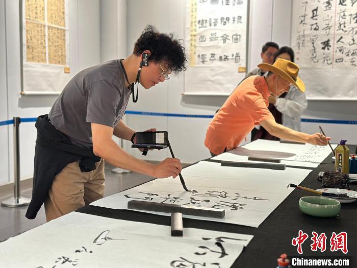6月18日,甘肃酒泉市瓜州县,两岸嘉宾体验书法,展开交流。闫姣 摄