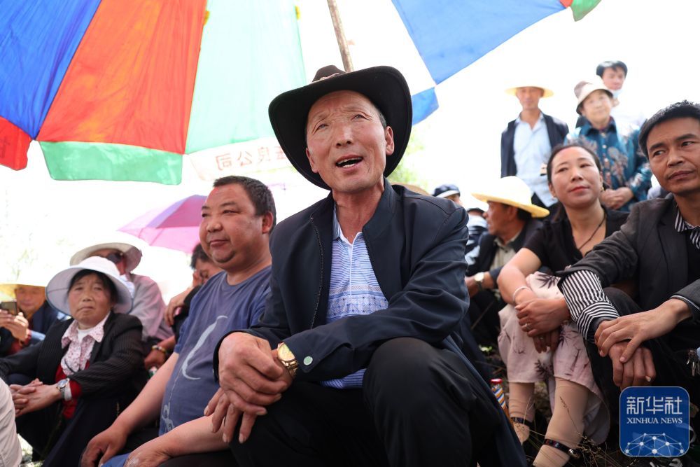 6月10日，在甘肃省定西市岷县洮河边的一场“花儿会”上，岷县寺沟镇巴仁村村民袁虎珍（中）在唱“花儿”。