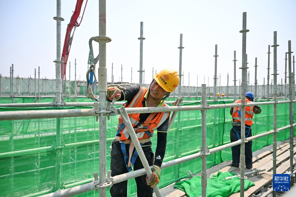 6月18日，中铁建设集团工人在雄忻高铁望都北站建设现场施工。