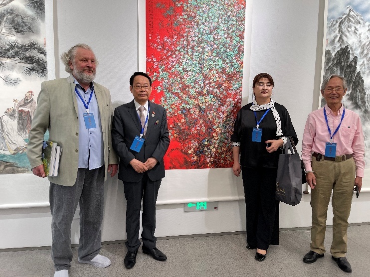 （从右至左）上合组织双年展组委员会常务主任顾宏、上合组织秘书处代表、俄罗斯艺术家联盟金奖获得者扎伊尔柯夫·亚历山大在萧晖荣作品前留影