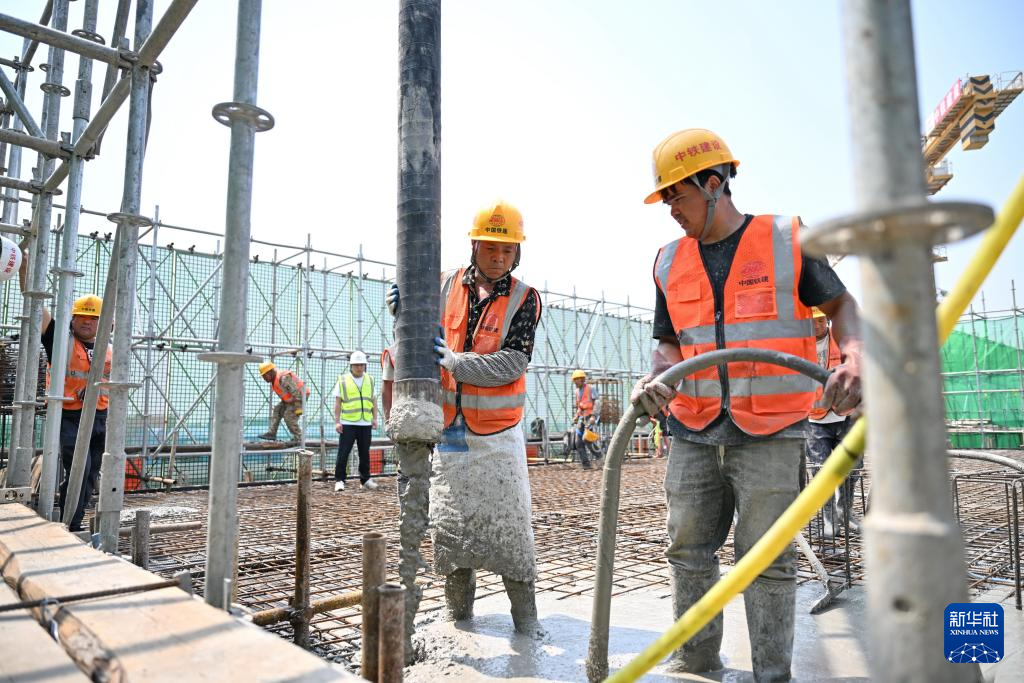 6月18日，中铁建设集团工人在雄忻高铁望都北站建设现场浇筑水泥。