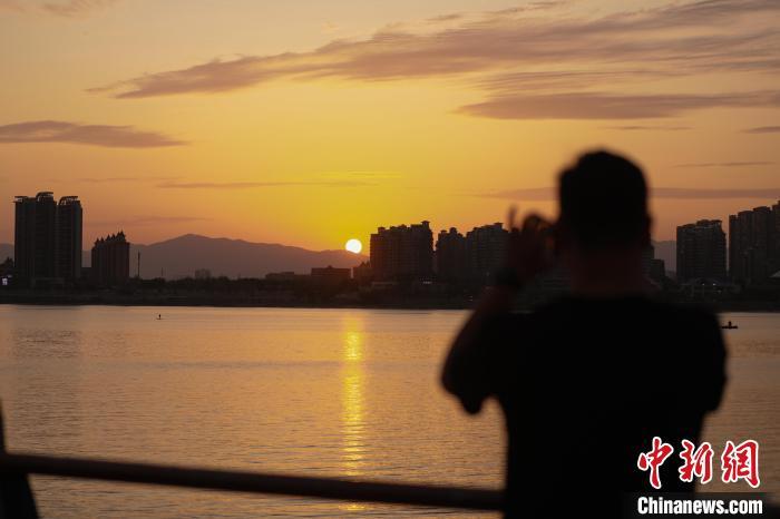 6月16日傍晚，江西南昌上空落日美景，晚霞满天，不少民众来到朝阳江滩公园欣赏晚霞美景。中新社记者 刘思伟 摄