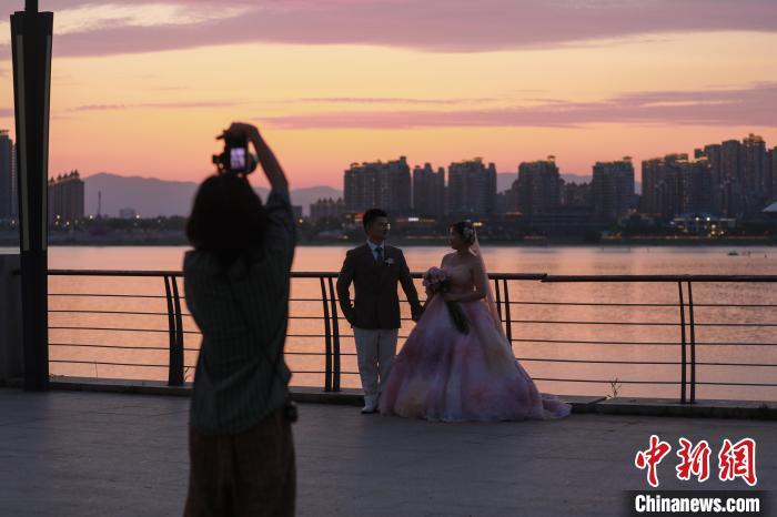 6月16日傍晚，江西南昌上空落日美景，晚霞满天，不少民众来到朝阳江滩公园欣赏晚霞美景。中新社记者 刘思伟 摄