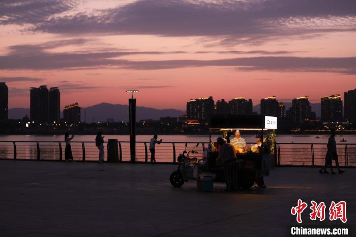 6月16日傍晚，江西南昌上空落日美景，晚霞满天，不少民众来到朝阳江滩公园欣赏晚霞美景。中新社记者 刘思伟 摄