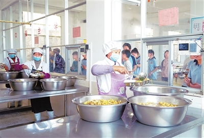 会昌县站塘初中食堂，后勤人员将热气腾腾、荤素搭配的饭菜送到学生手中。