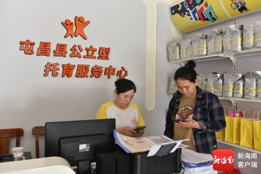 保育员（左）在指导家长郑佩佩（右）使用托育消费券。通讯员 林小丹 摄