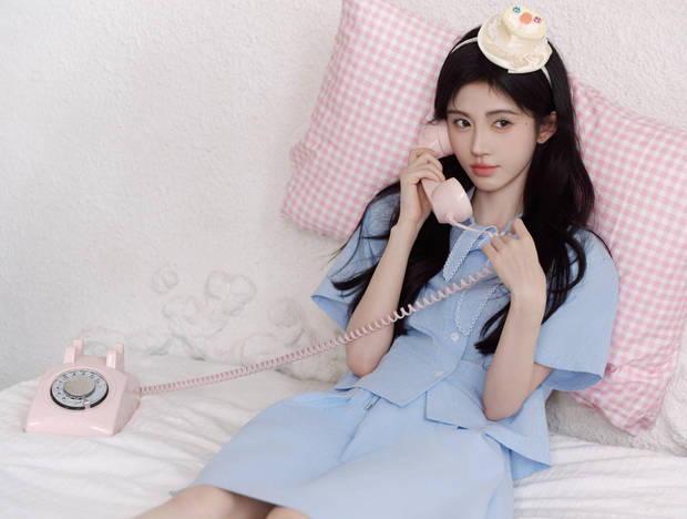 鞠婧祎靠在粉色枕头上打电话，少女感十足。