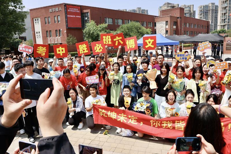 在西安市曲江第一中学考点，考生和家长开心合影。记者 郝钟毓 实习生 郝雨辰一摄