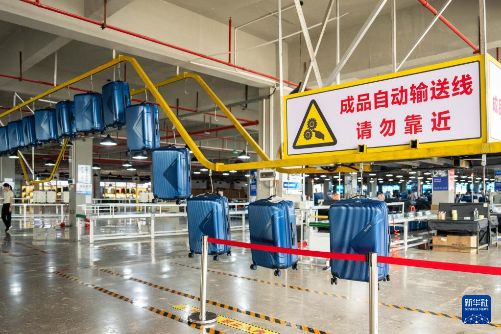 6月23日，在蓝山县皮具箱包科技产业园一家箱包生产企业，自动输送线在运输拉杆行李箱成品。