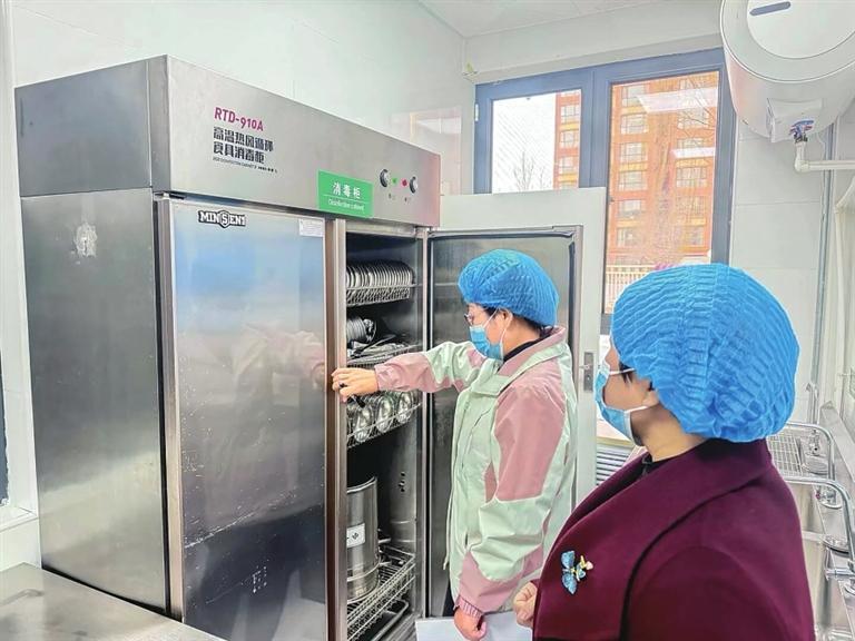 工作人员仔细检查厨房用具清洁情况