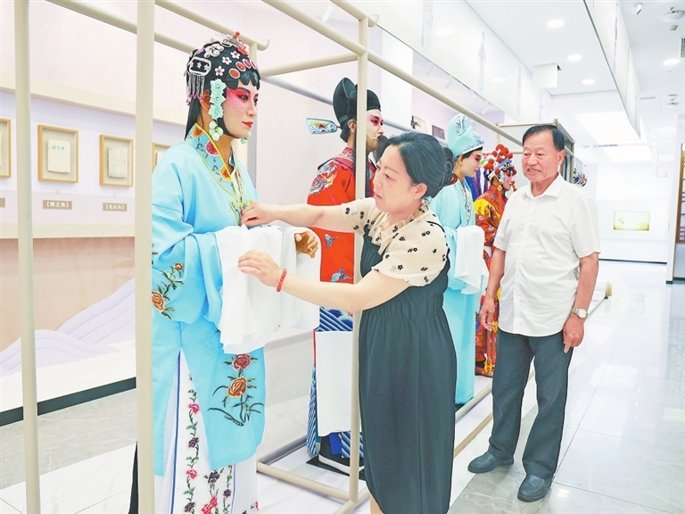 西河戏代表性传承人在整理服饰道具。　　本报全媒体记者 徐黎明摄