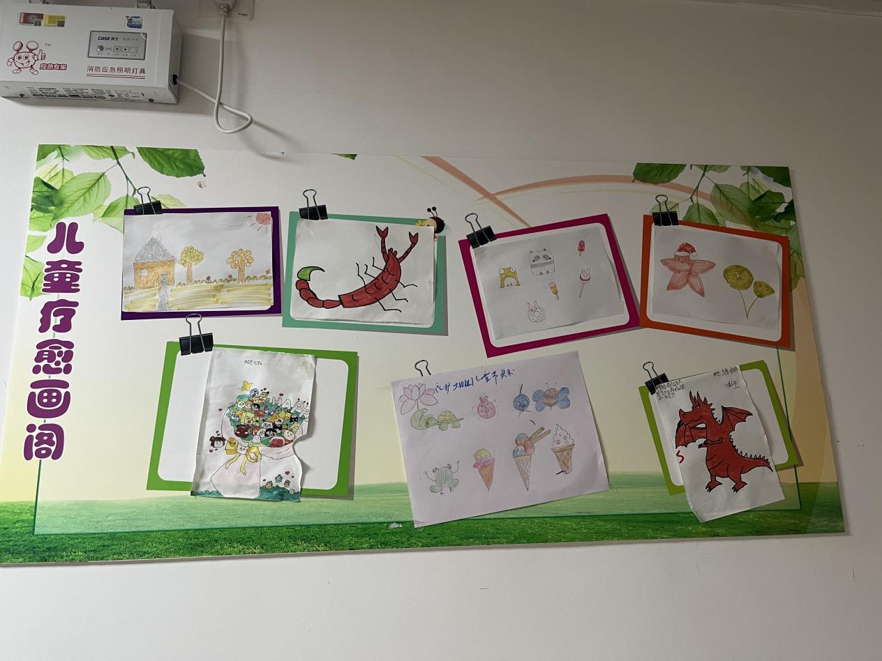 图为:病房里,展示着小朋友们的画画。