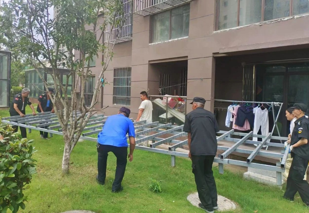 图为新城办城管队员拆除小绿化带违章建设。