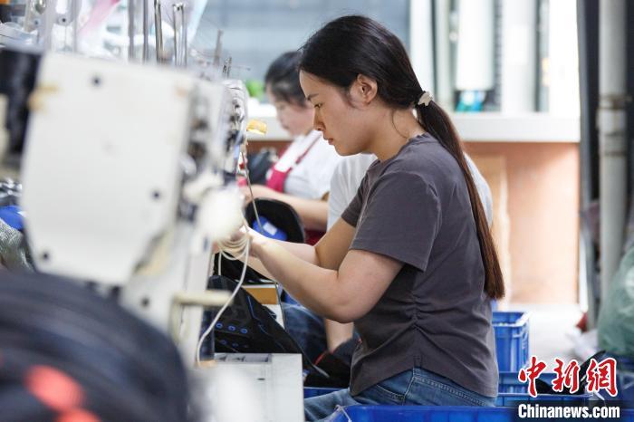 图为工人们在加工运动鞋。郭显升 摄