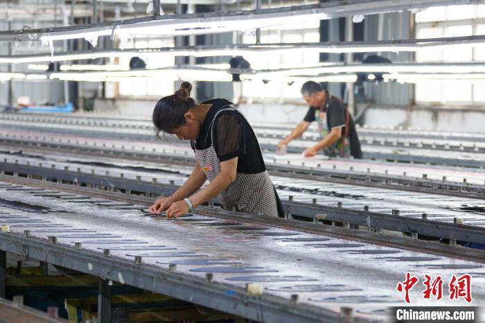 图为工人们在加工运动鞋。郭显升 摄