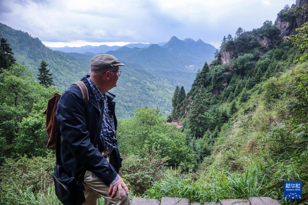 6月25日，在甘肃省临夏回族自治州康乐县莲花山上，高文厚沿着山路攀登准备去参加“莲花山花儿会”。新华社发（刘久鸣　摄）