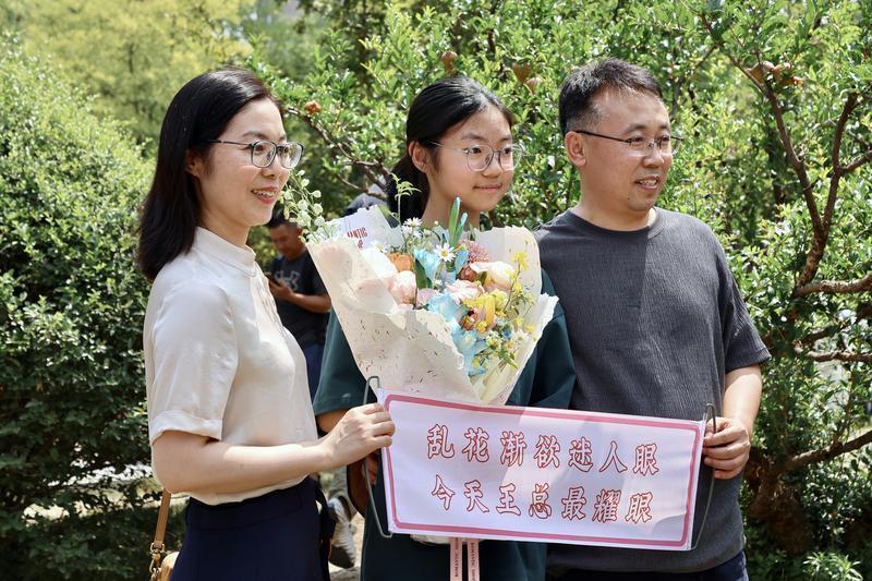 在西安市曲江第一中学考点，考生和家人合影。记者 郝钟毓 实习生 郝雨辰一摄