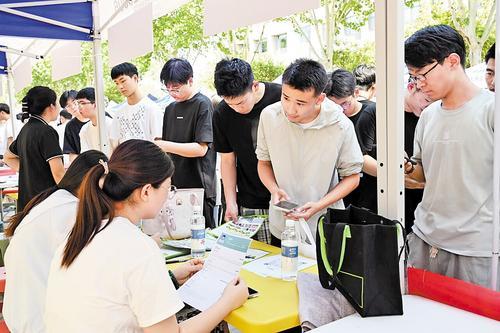 6月21日，河北机电职业技术学院举办“2025年毕业生夏季双选会”。这是学生在了解岗位信息，投递个人简历。 本报记者 闫德见摄