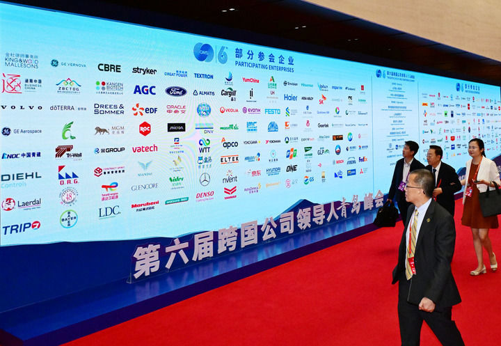 2025年6月19日，第六届跨国公司领导人青岛峰会与会者在开幕式后经过参会企业标志墙。新华社记者 李紫恒 摄