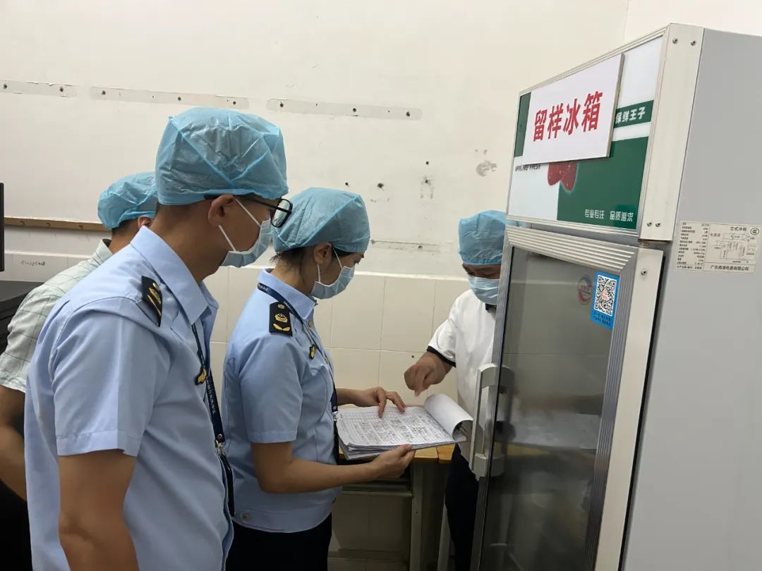 ▲市市场监管局工作人员核查中考考点留样冰箱记录表。