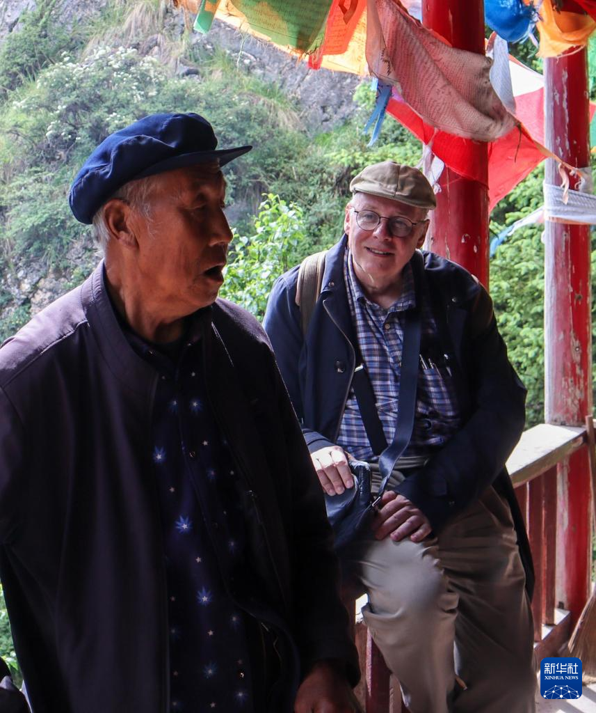 6月25日，在甘肃省临夏回族自治州康乐县莲花山上，高文厚听一名当地群众唱“花儿”。新华社发（刘久鸣　摄）