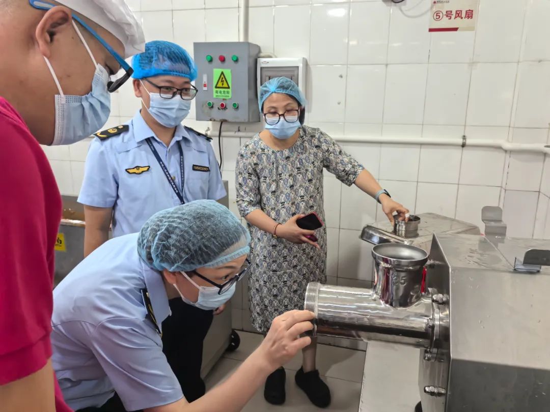 ▲顺德区市场监管部门工作人员在养正学校检查设备卫生情况。