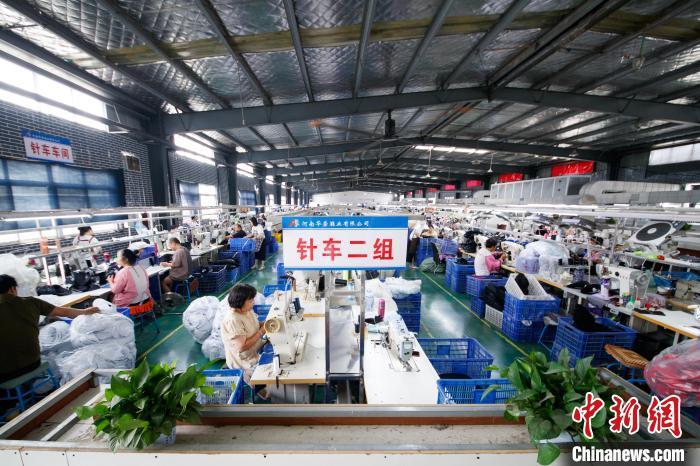 图为工人们在加工运动鞋。郭显升 摄