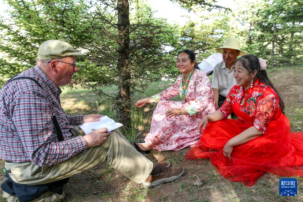 6月11日，在甘肃省定西市岷县二郎山上，高文厚采访“花儿”歌手。新华社记者　郎兵兵　摄