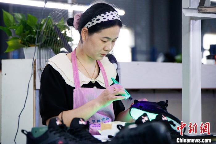 图为工人们在加工运动鞋。郭显升 摄