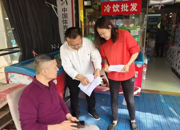 图为人民社区残疾人工作者向个人创业扶持对象宣传政策。