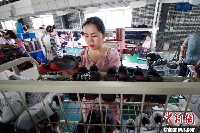图为工人们在加工运动鞋。郭显升 摄