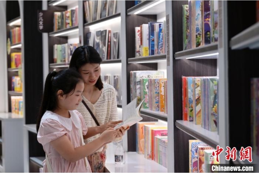 7月2日，河北石家庄一书店，小女孩在母亲陪伴下阅读。中新社记者 翟羽佳 摄