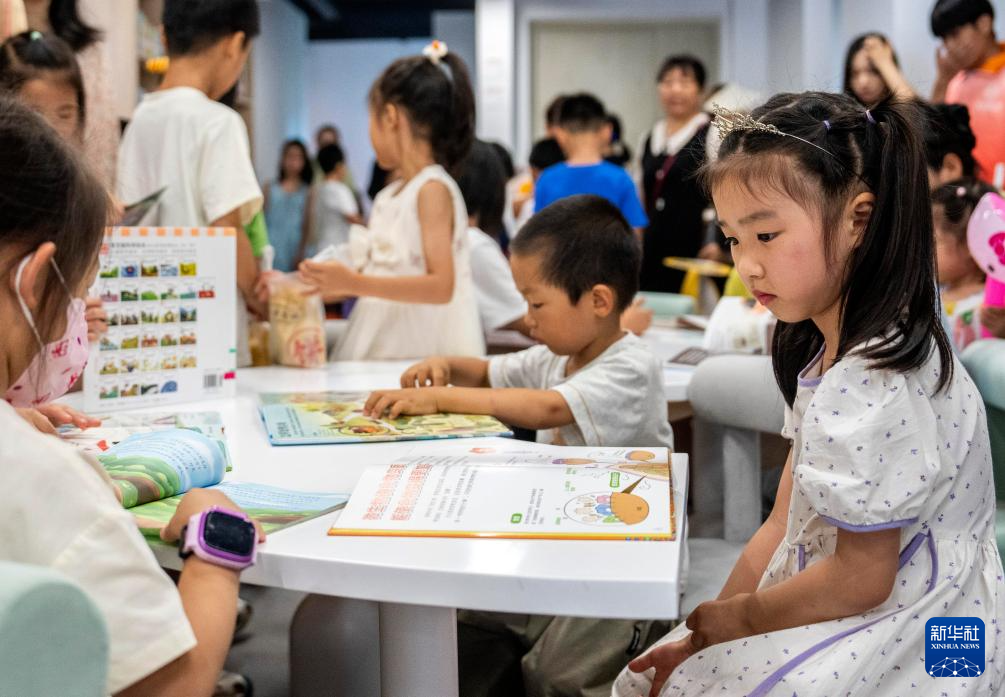 6月28日,在长沙图书馆湘江新区周家湾分馆,小朋友在阅读图书。