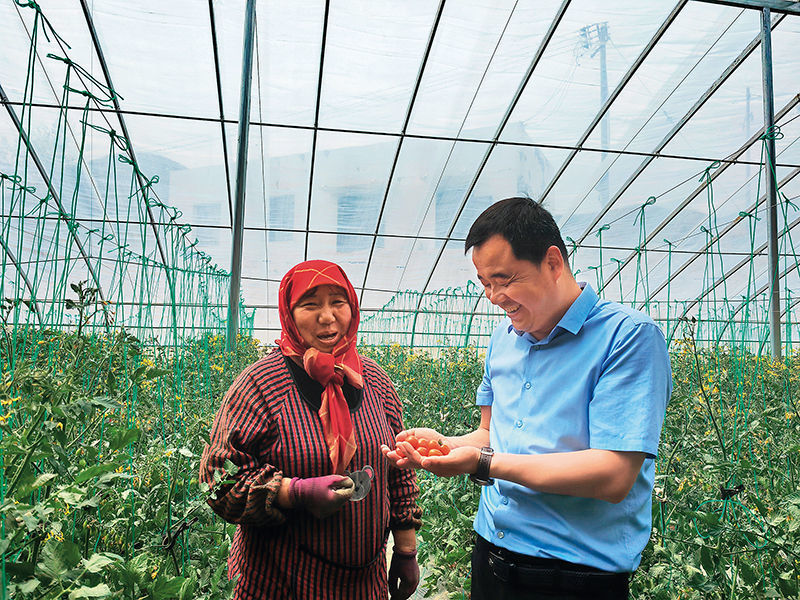 魏正家(右一)在温室内与村民交谈(2025年5月20日摄)崔翰超 摄/本刊
