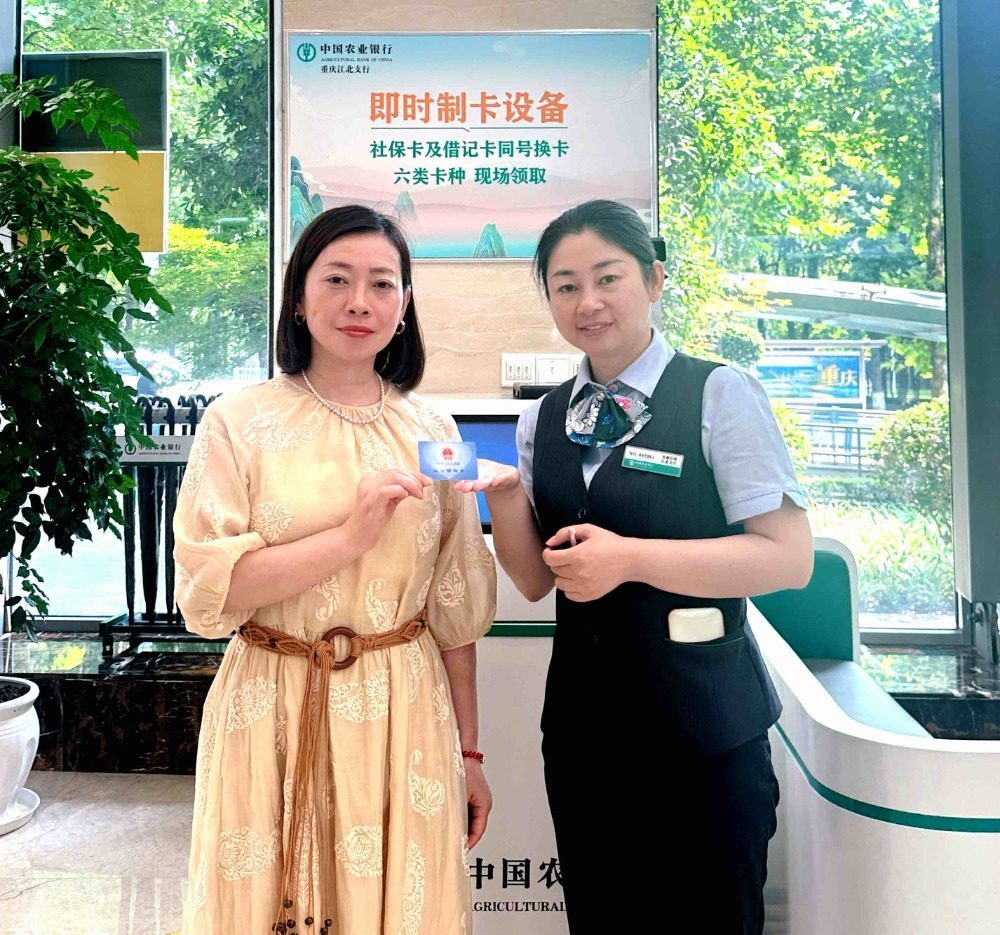 ▲张女士领到我市首张社保卡同号即换即领。