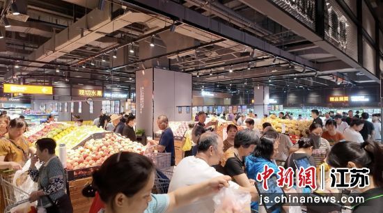 市民们在商超中选购商品。