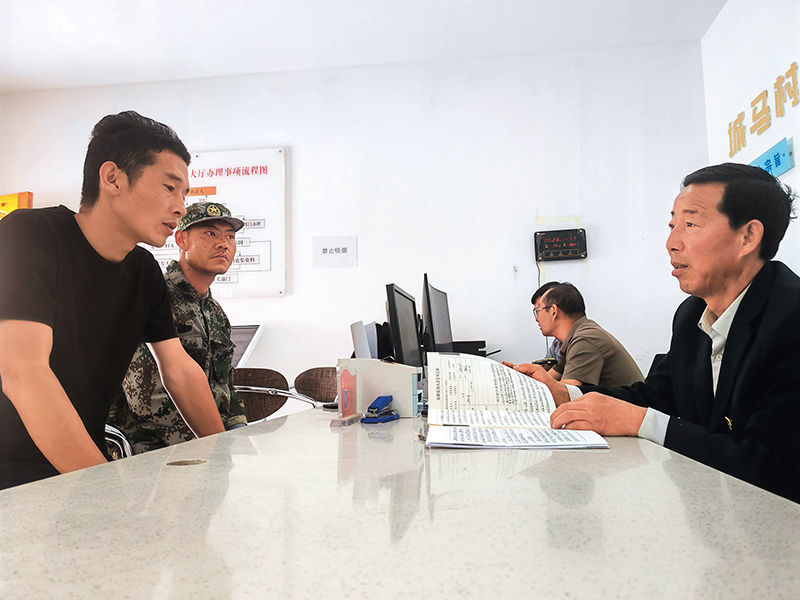 张俊师(右一)正在为前来咨询的村民答疑解惑(2025年5月23日摄)崔翰超 摄/本刊