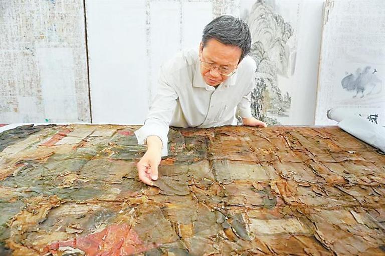 张文军正在查看已破损的纸质文物