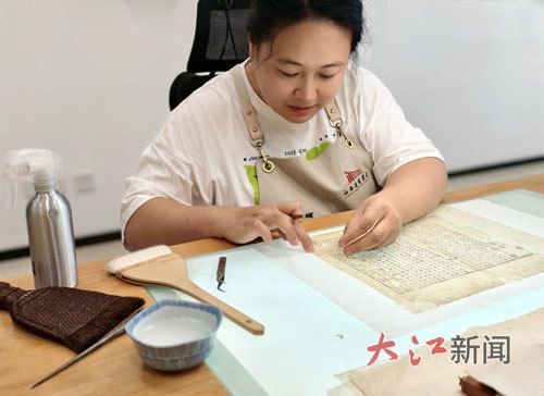 古籍修复师谭依玲正在修复书叶