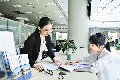 6月24日，沧州市行政审批局企业开办专区工作人员（左）指导一家公司相关负责人办理股权变更业务。 本报记者王雅楠摄