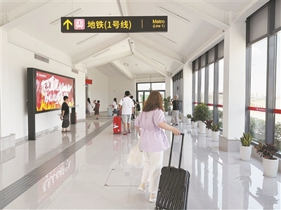 下飞机的旅客通过风雨连廊转乘地铁