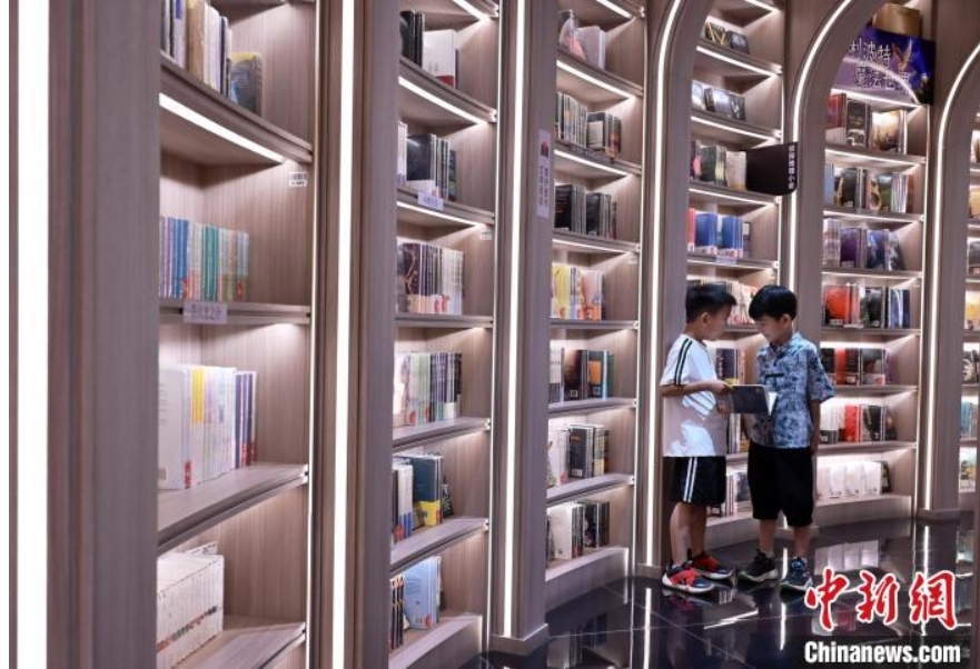 7月2日，河北石家庄一书店，拿着书的男孩正与同伴交流。中新社记者 翟羽佳 摄