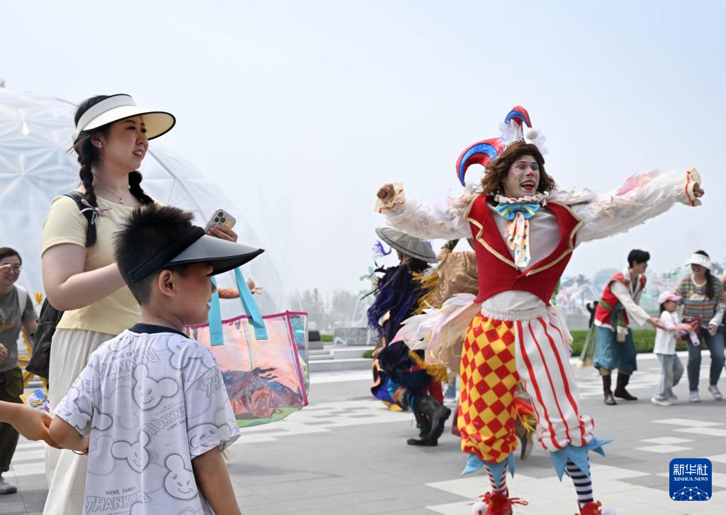 6月28日，游客在“彩虹广场”上观看演员互动表演。新华社记者 李紫恒 摄