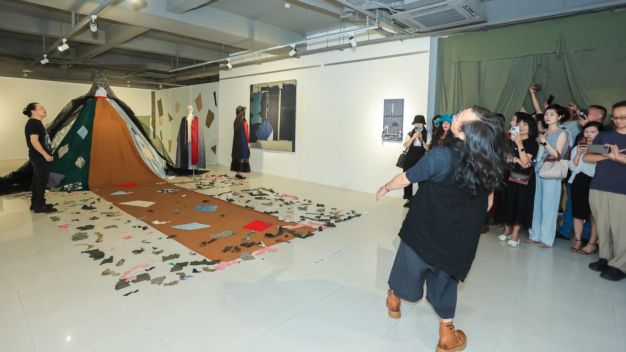 参展艺术家卢文（中）在展览现场表演行为艺术