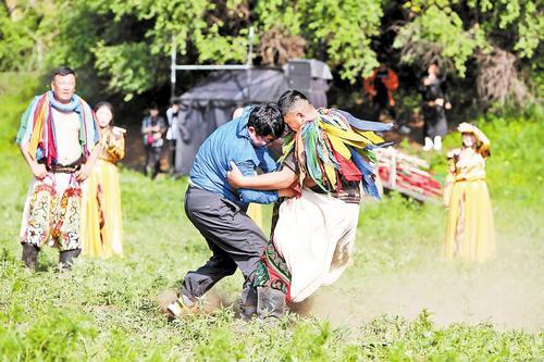 6月23日，在位于张北县的草原天路野狐岭生态旅游区，游客与摔跤手互动。 武殿森摄