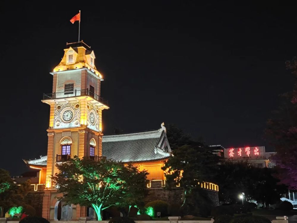 南通市地标建筑钟楼，与悬挂“英才辈出”字样的南通中学紧邻，成为当地一景。新华社记者柯高阳 摄