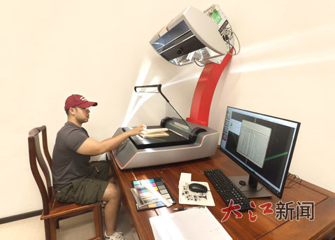 江西省图书馆数据采集室工作人员正在对古籍进行扫描上传