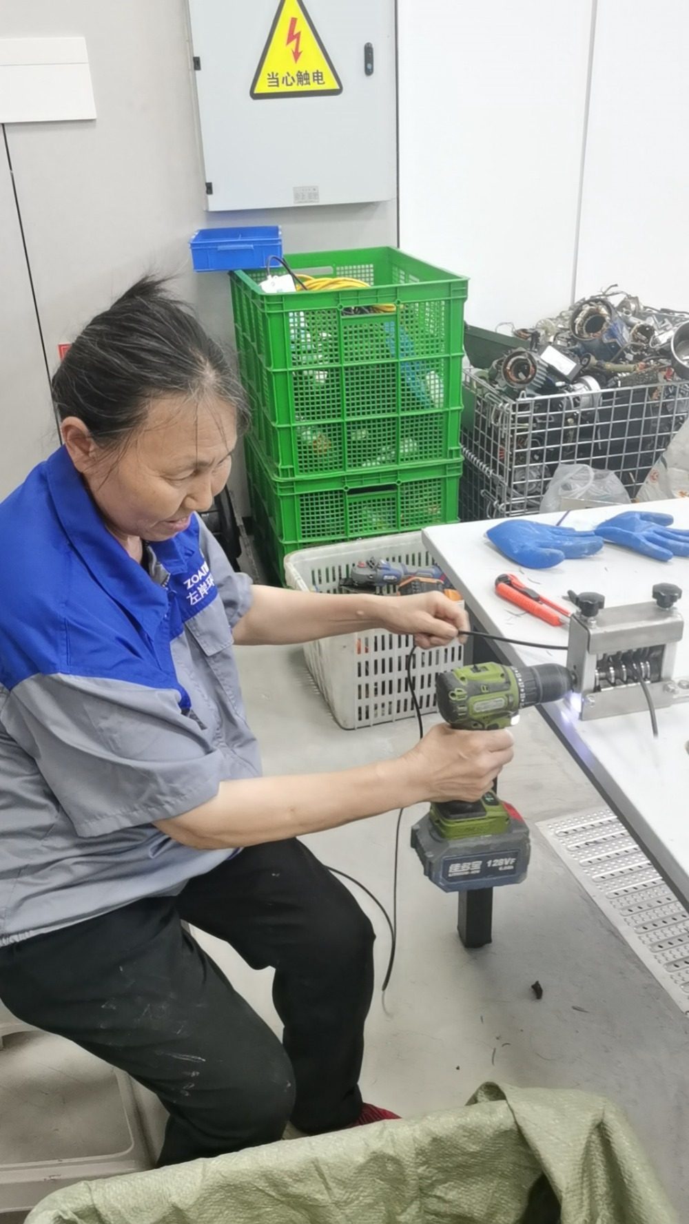 ▲江北区绿色生活驿站里的工作人员正在拆卸废旧电线。记者 余虎 摄